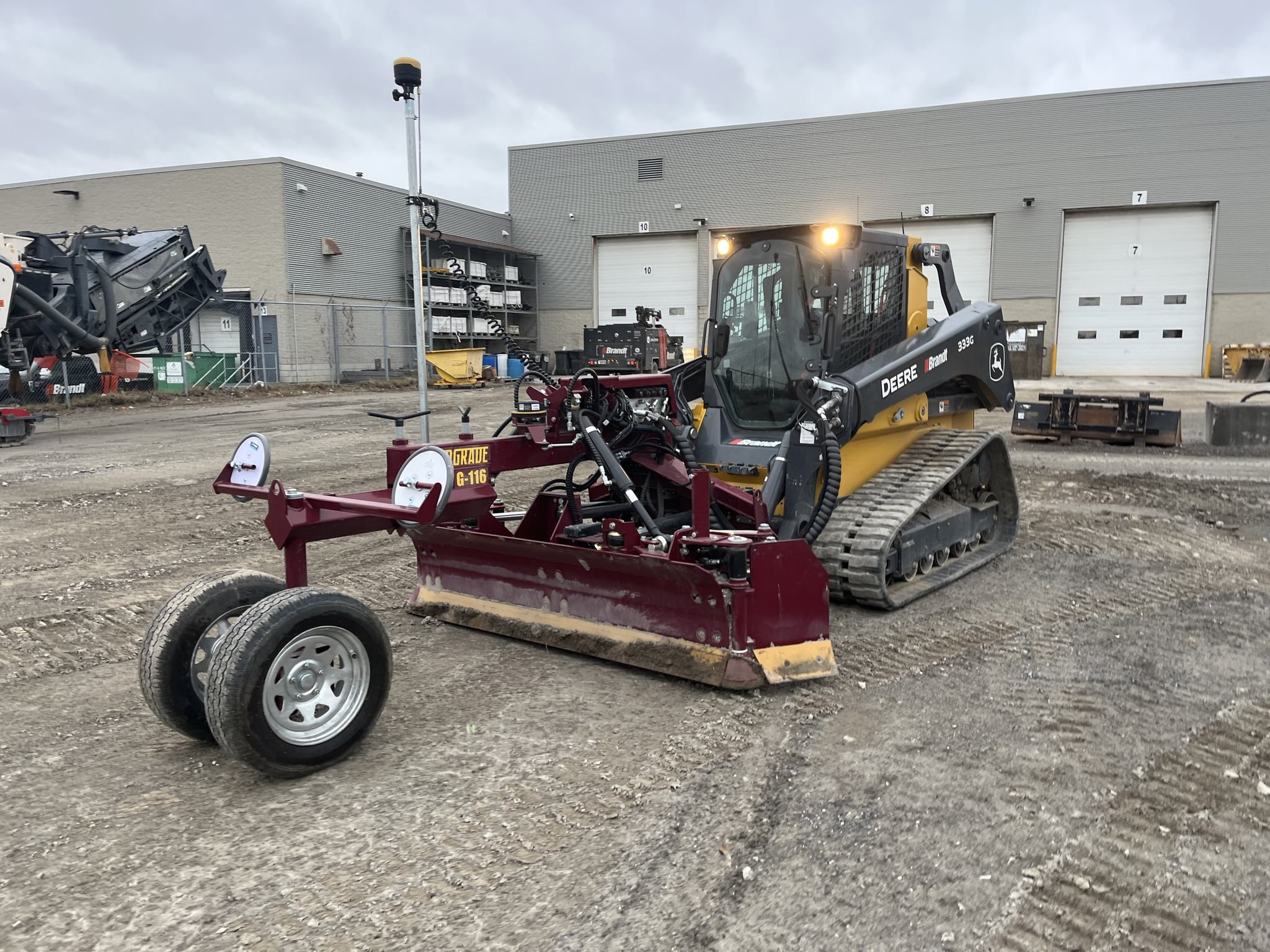 John Deere 333G Skid steer with plane or grading attachment.