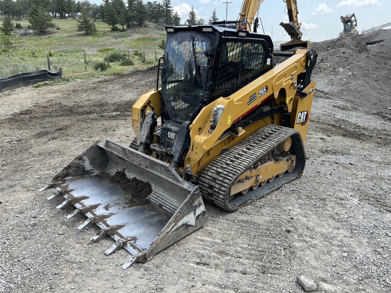 Caterpillar 265 Track Loader featuring a bucket with teeth.