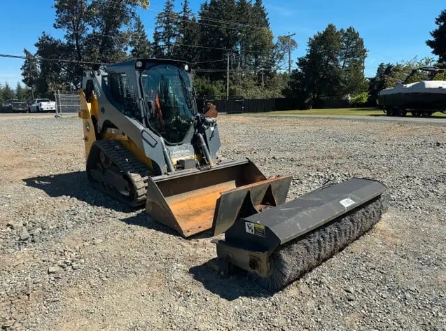 John Deere track loader with sweeper attachment.