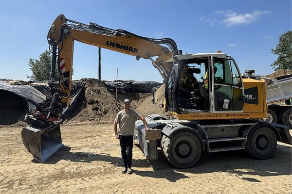 Liebherr A918 Compact Excavator: Size Meets Capability. Pictured: Faubert Precision Contracting Ltd. owner Ken Faubert with his Liebherr A 918 Compact Litronic wheel excavator, the foundation of his growing business.